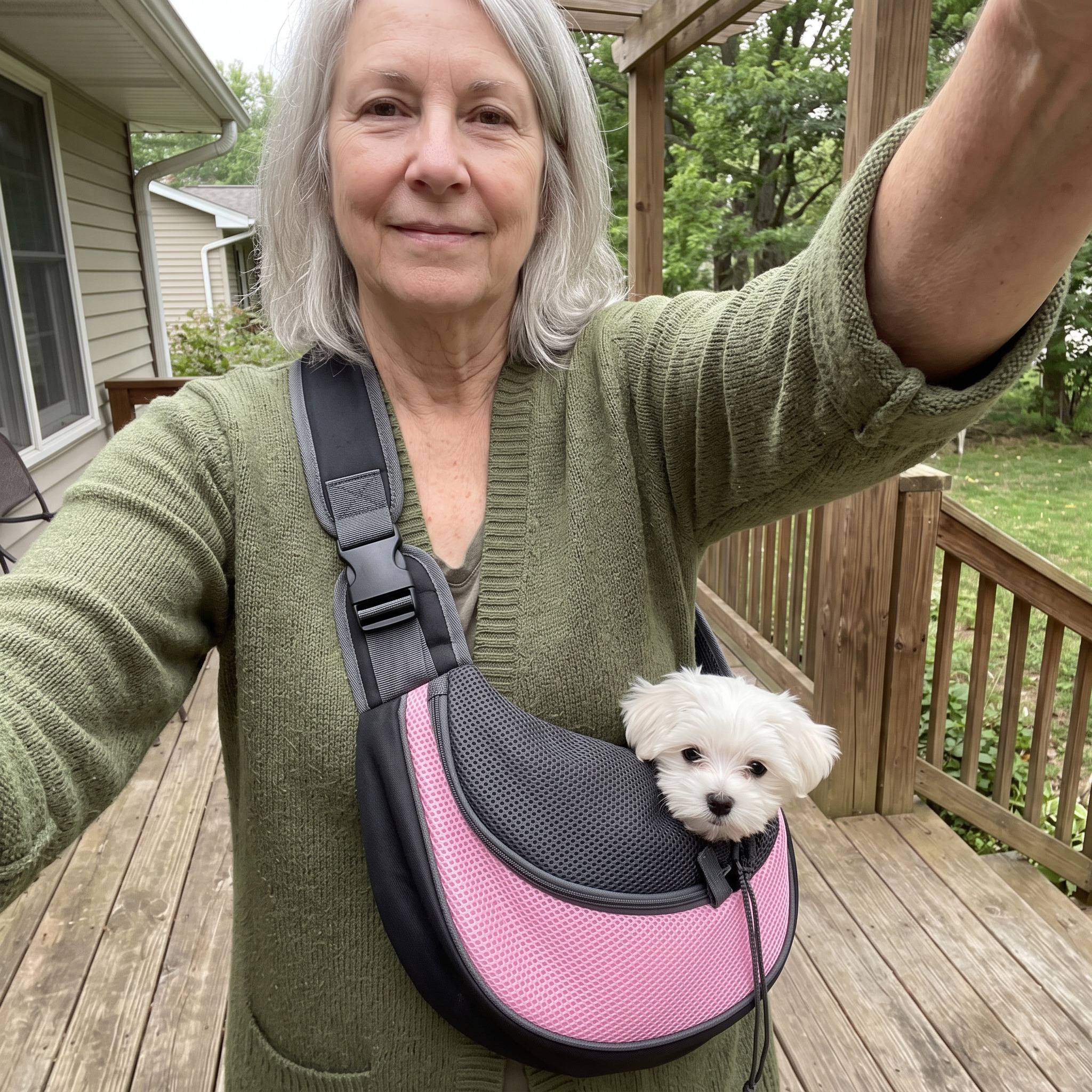 Older woman taking a porch selfie with a Maltese in a Pink sling
