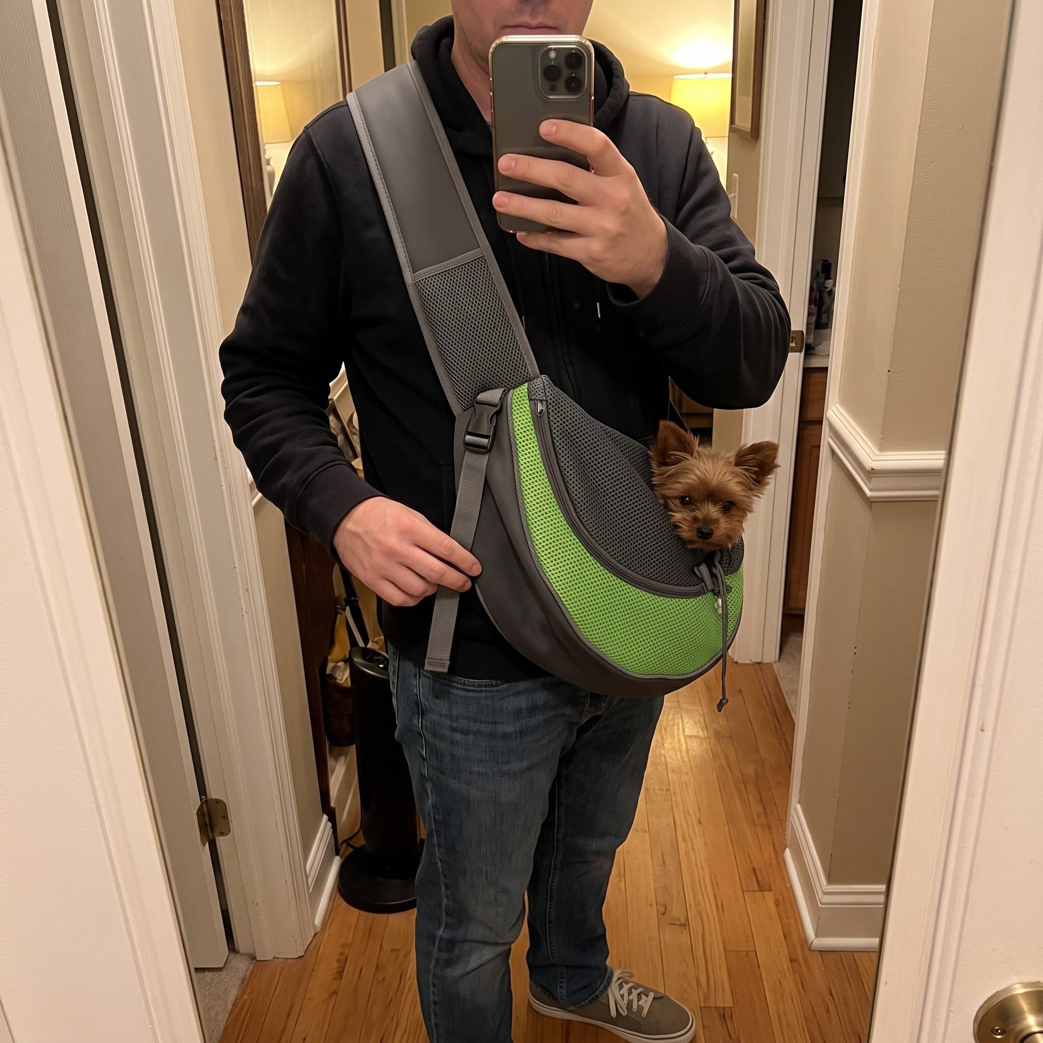 Hand adjusting the strap of a Green sling at a hallway mirror